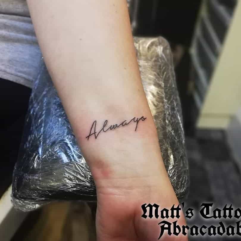 Tattoo of the word "Always" in cursive script on a wrist