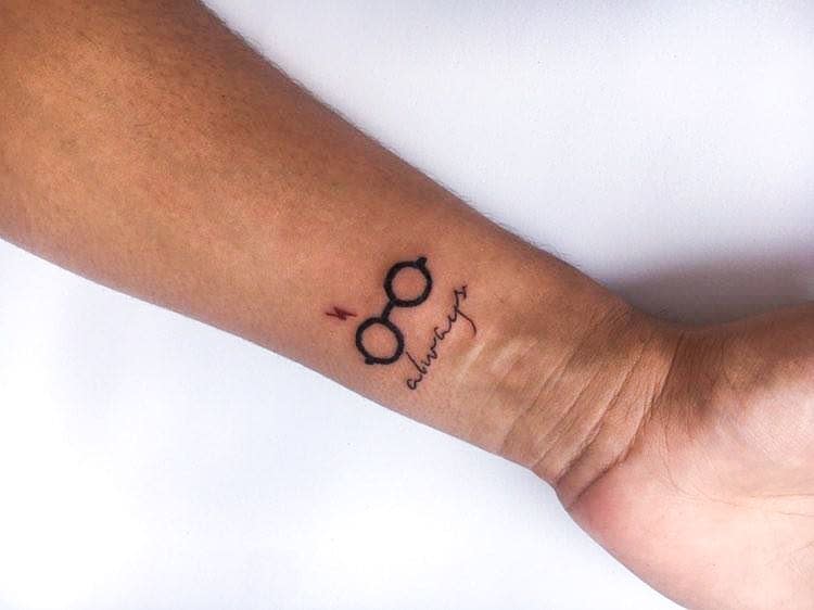 Minimalist Harry Potter-themed wrist tattoo featuring glasses, a lightning bolt, and 'always' in cursive, symbolizing magic and loyalty