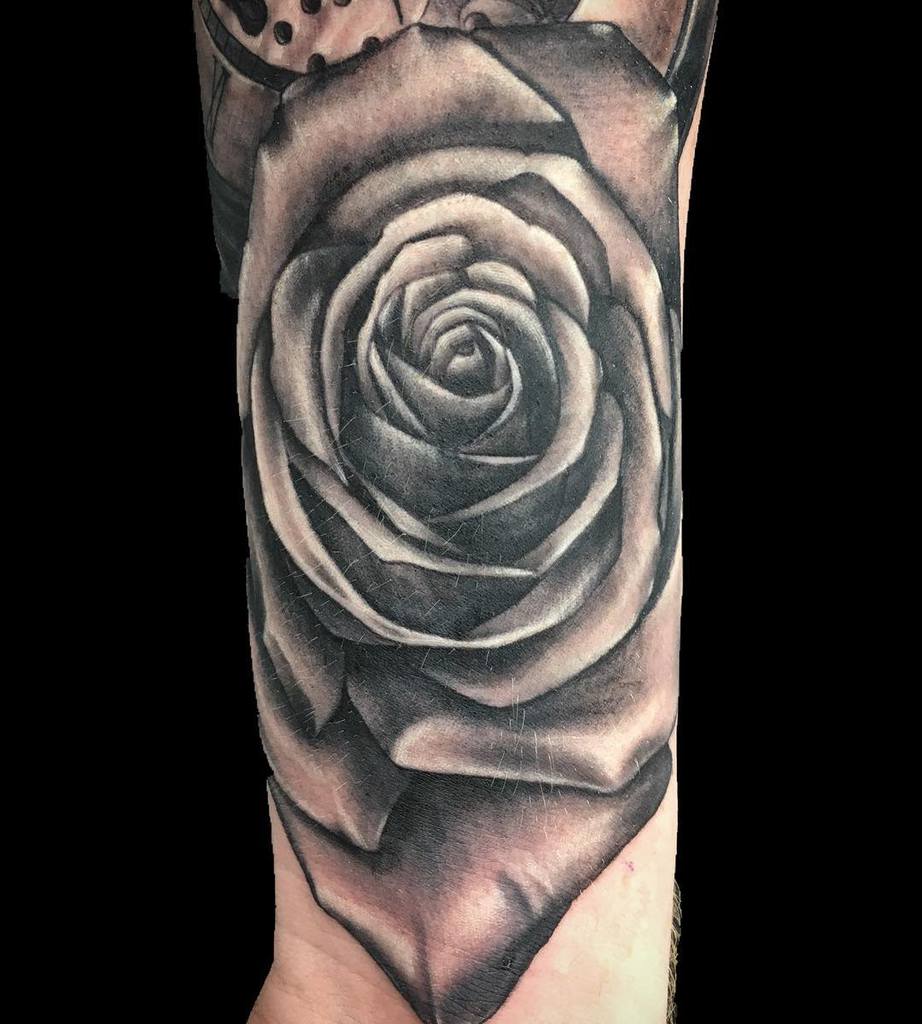 Black and gray realistic rose tattoo on a wrist