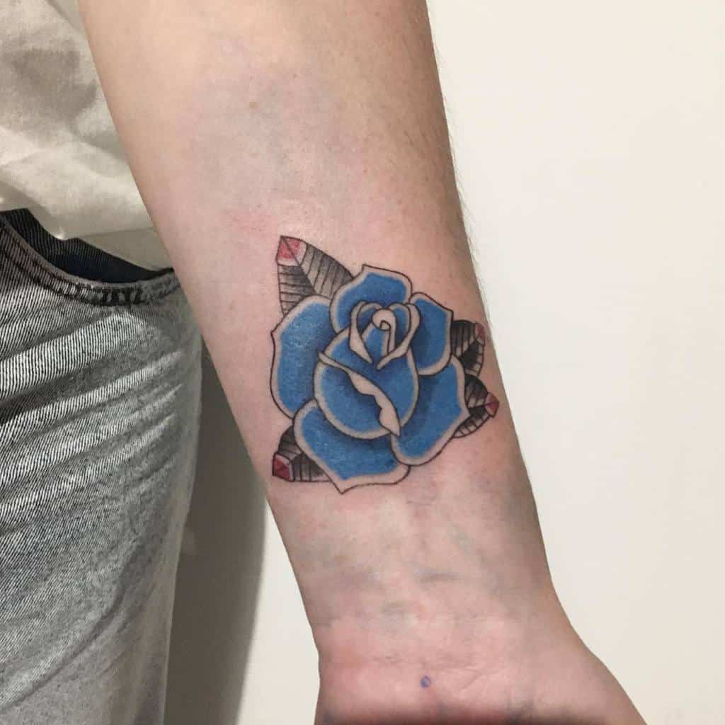 A blue rose tattoo on a wrist with geometric patterns