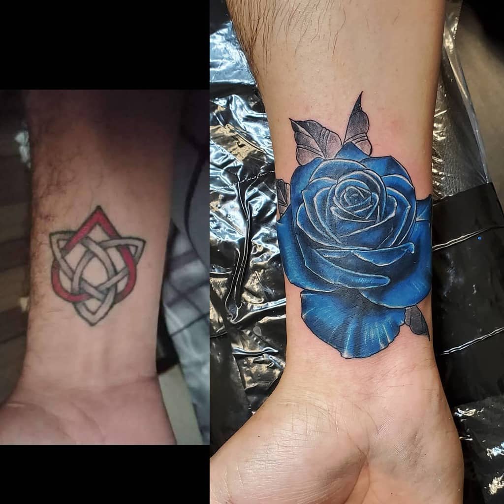A cover-up tattoo showing the transformation from a geometric knot design on the wrist to a vibrant blue rose on the forearm, showcasing detailed shading and realistic depth