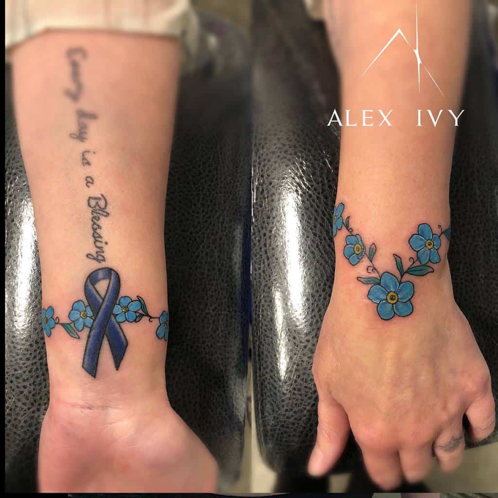 A beautiful tattoo featuring blue forget-me-nots intertwined with a ribbon, symbolizing awareness, and accompanied by the text "Every day is a blessing" on the wrist
