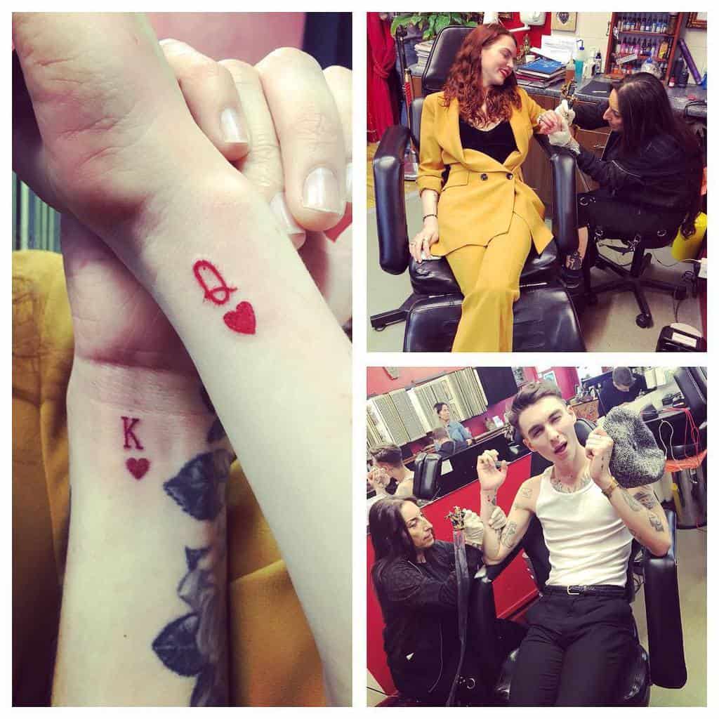 Matching wrist tattoos showcasing a minimalist Queen of Hearts and King of Hearts design in vibrant red ink