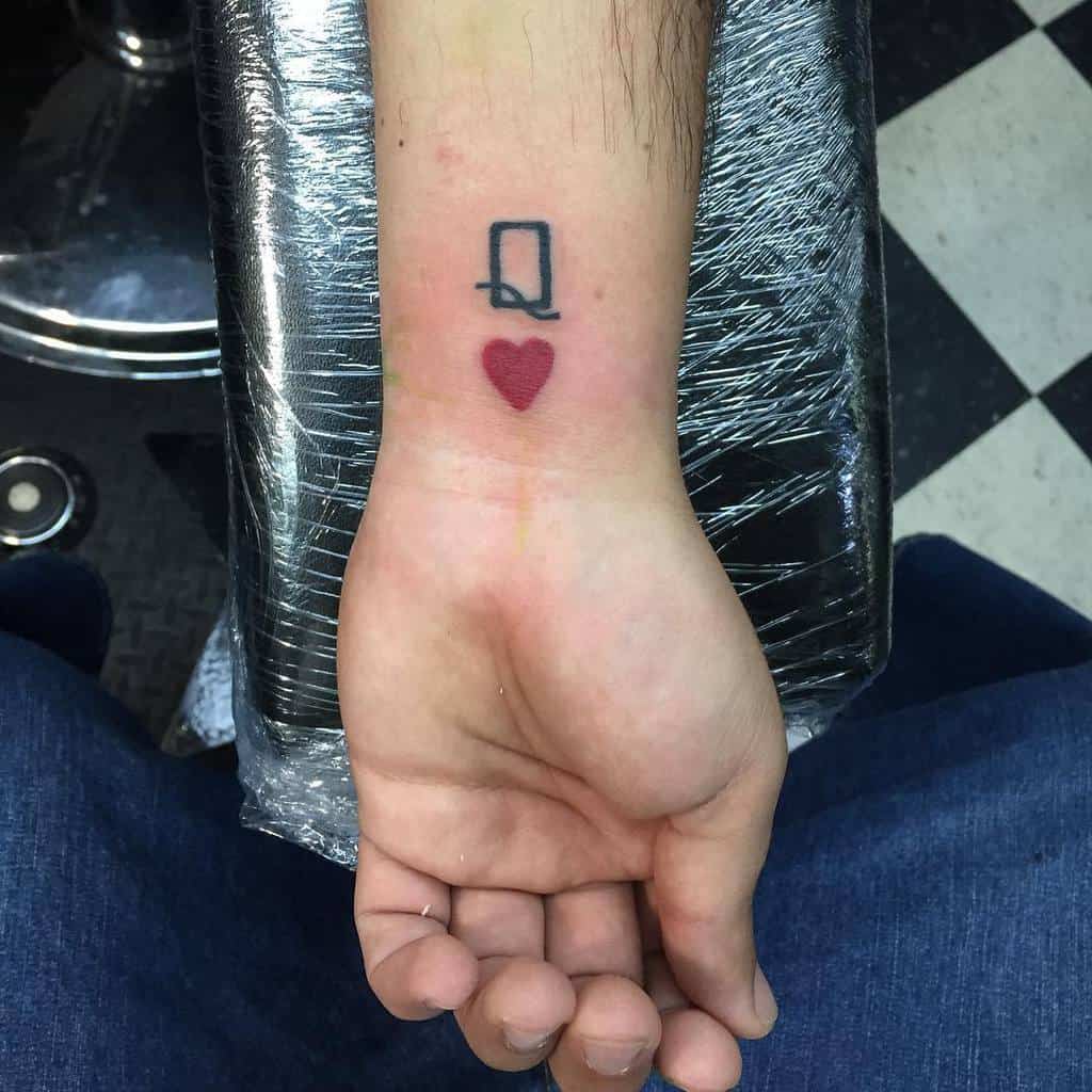Tattoo of a queen of hearts card symbol on a wrist