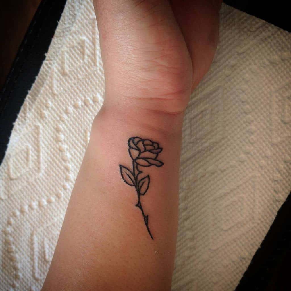 Simple black rose tattoo on a wrist