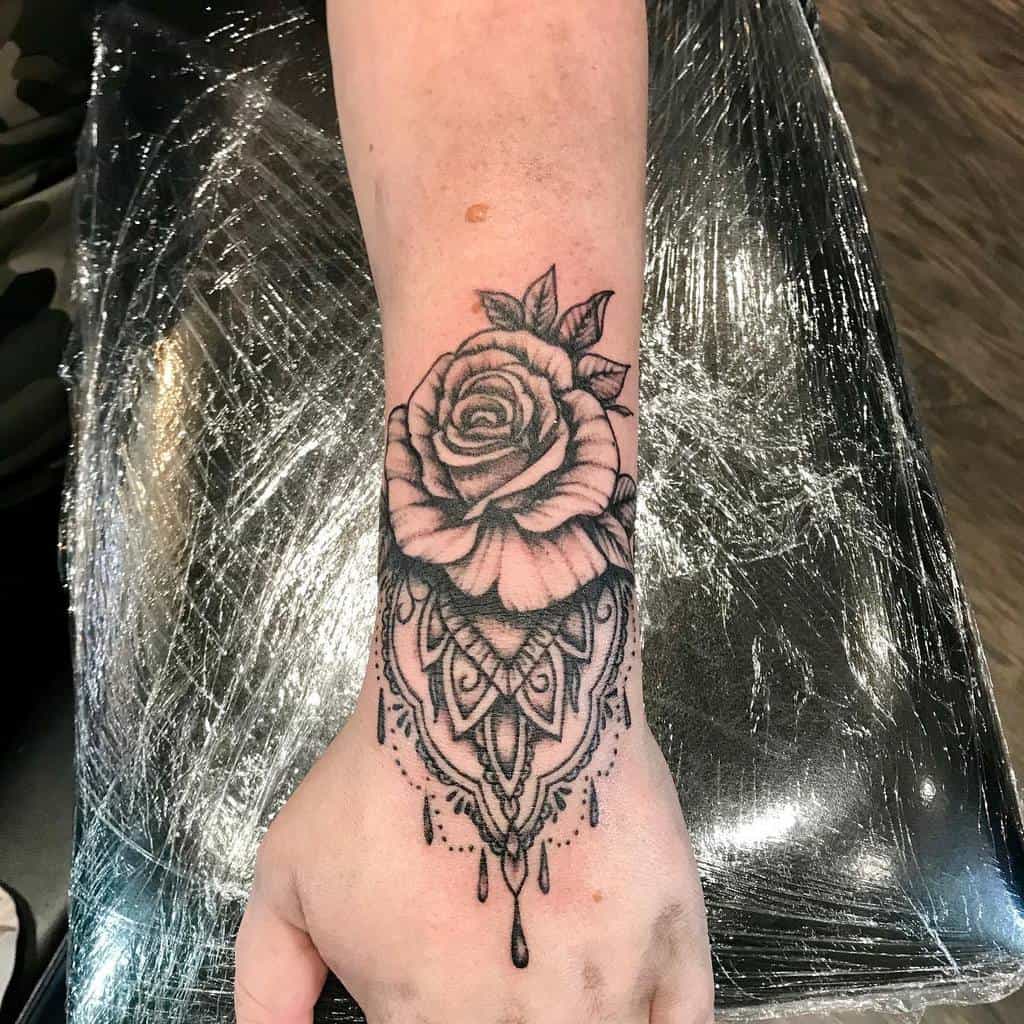 Black rose tattoo with intricate designs on a wrist