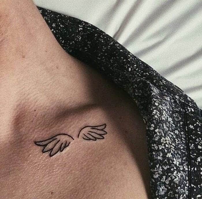 Minimalist angel wings tattoo outlined in black ink, symbolizing freedom and spirituality