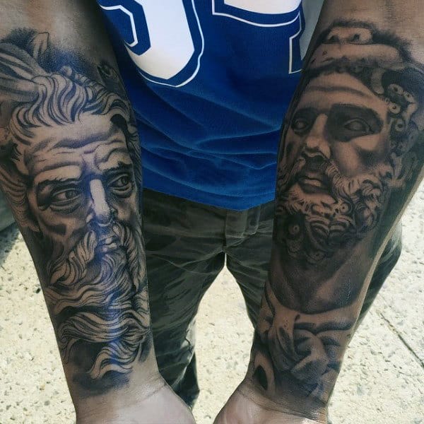 Two tattooed forearms showing detailed portraits of ancient, bearded men