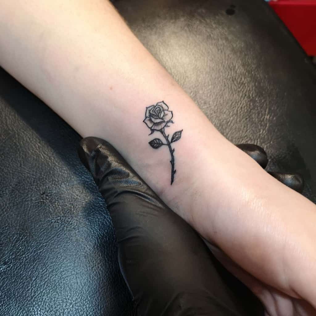 Black rose tattoo on a wrist