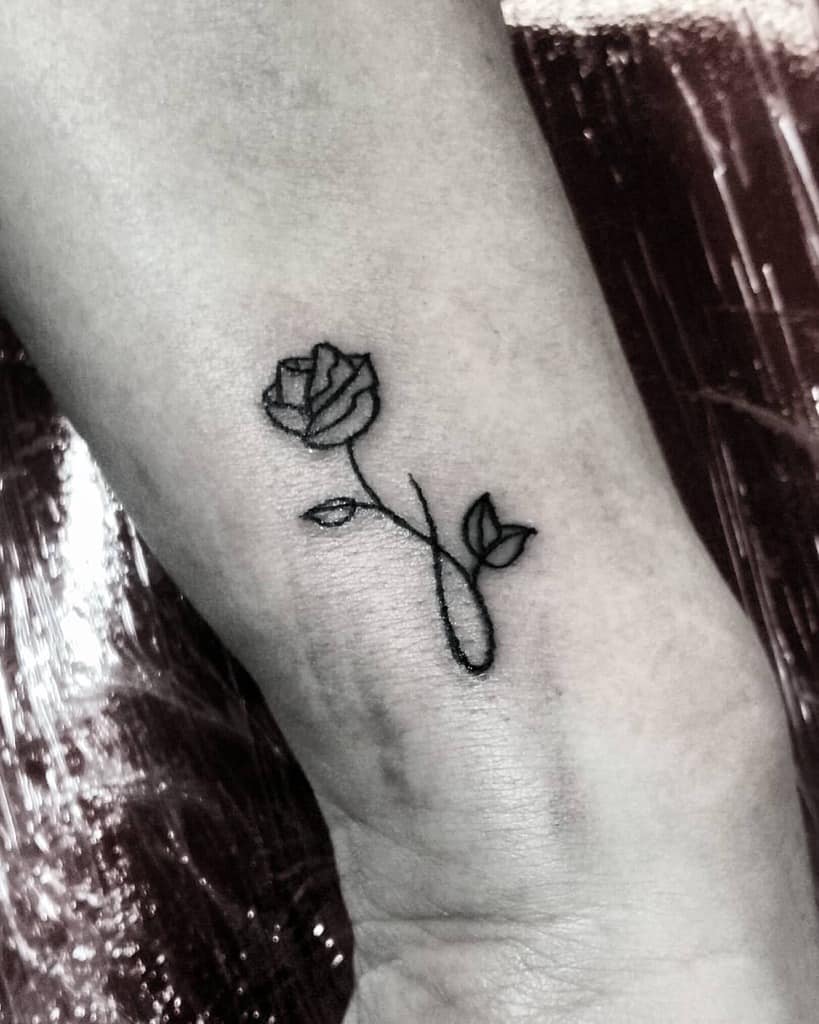 Black ink rose tattoo on an inner wrist