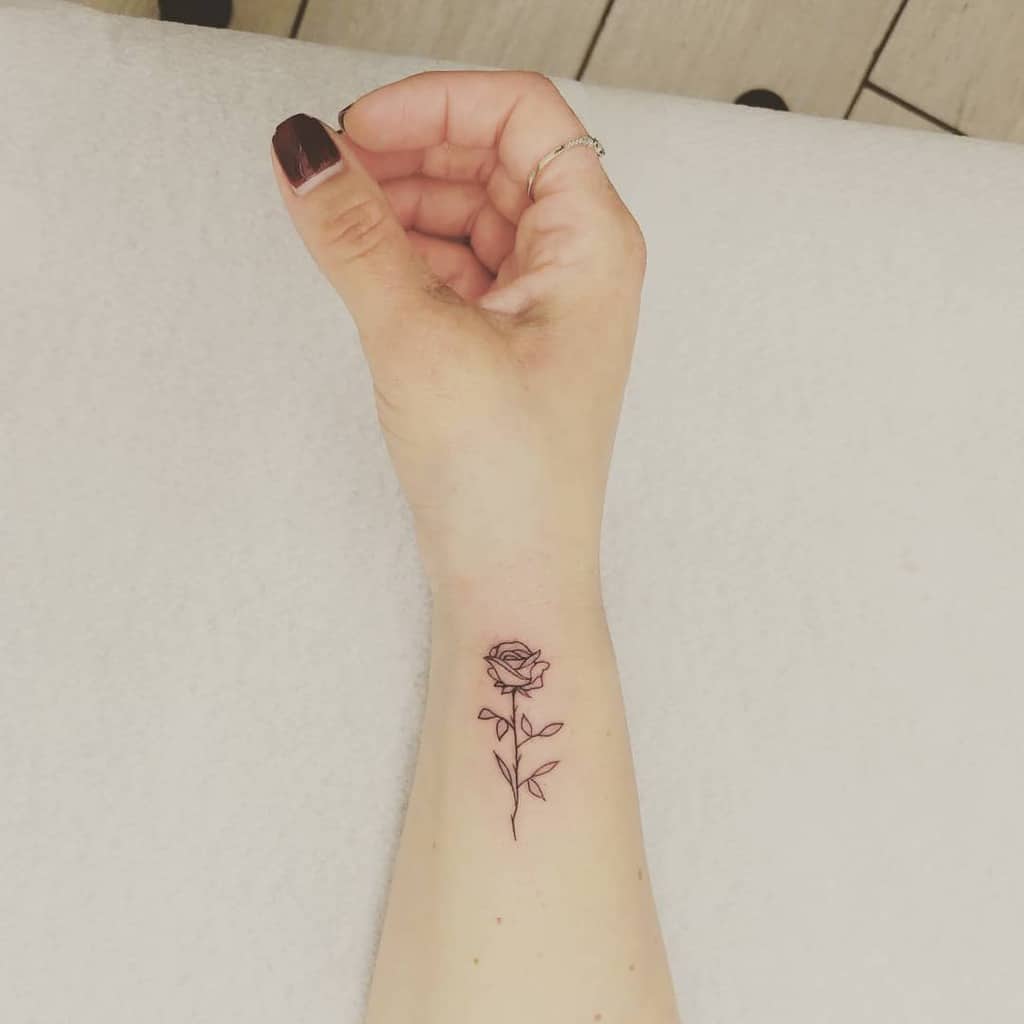 A minimalist rose tattoo on a wrist