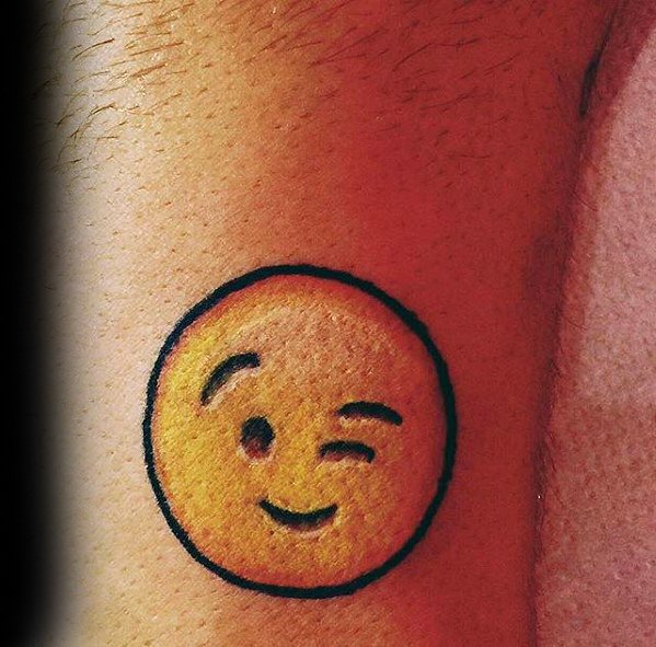 Winking emoji tattooed on skin