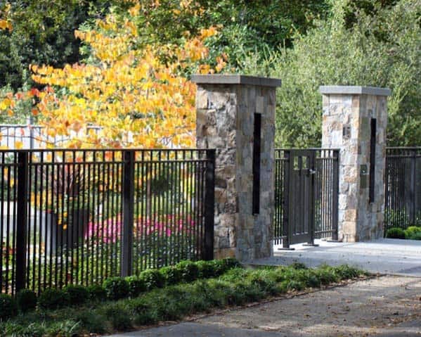 wrought iron black front yard fence with stone pillars