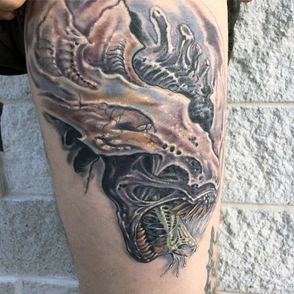 Detailed Xenomorph tattoo with muted tones, showing the creature’s open mouth, dripping saliva, and elongated head with eerie textures.
