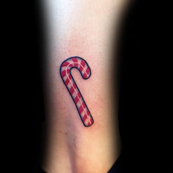 Minimalist Christmas tattoo of a classic red and white plaid candy cane, featuring clean lines and simple shading for a festive and subtle holiday design.