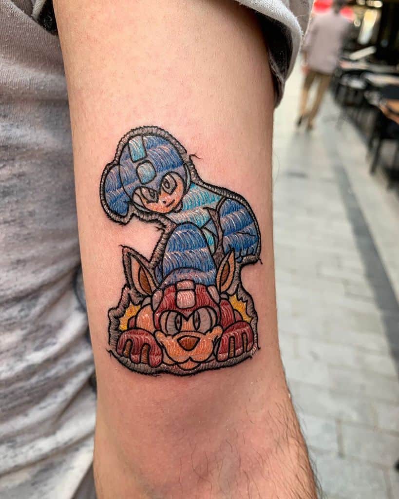 Tattoo of Mega Man and his robotic canine companion, crafted with an embroidered look and thread-like shading.
