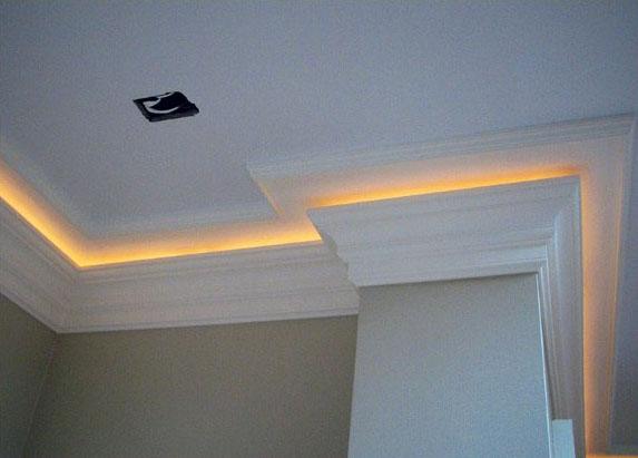 Soft yellow LED crown molding lighting, adding a warm and inviting glow to the room's ceiling design