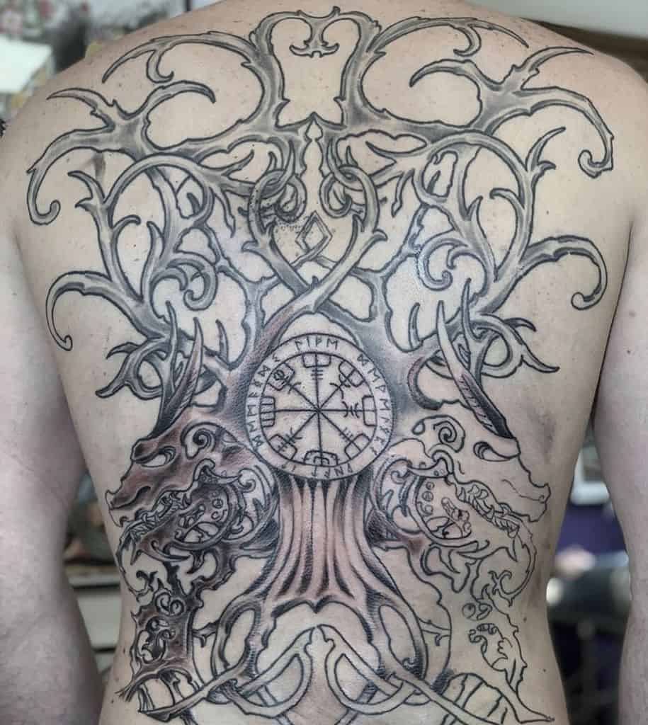 Norse-inspired back tattoo featuring Yggdrasil, Vegvísir runic compass, and Viking-style wolves with intricate knotwork and details.