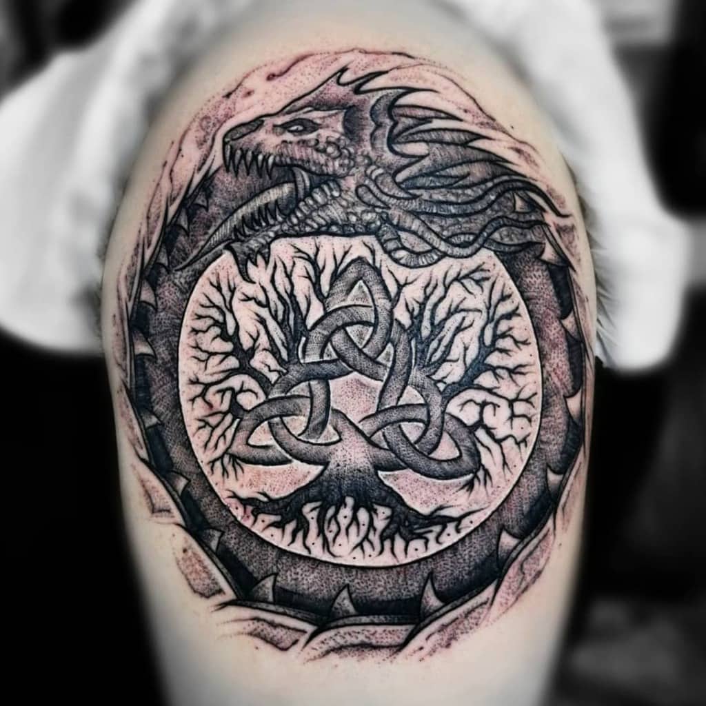 This tattoo features a dragon Ouroboros encircling a Celtic tree of life, symbolizing eternity, strength, and the cycle of existence.