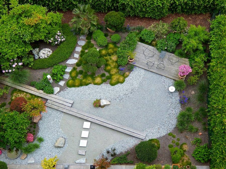aerial shot of backyard garden with large stone area wood deck green shrubs 