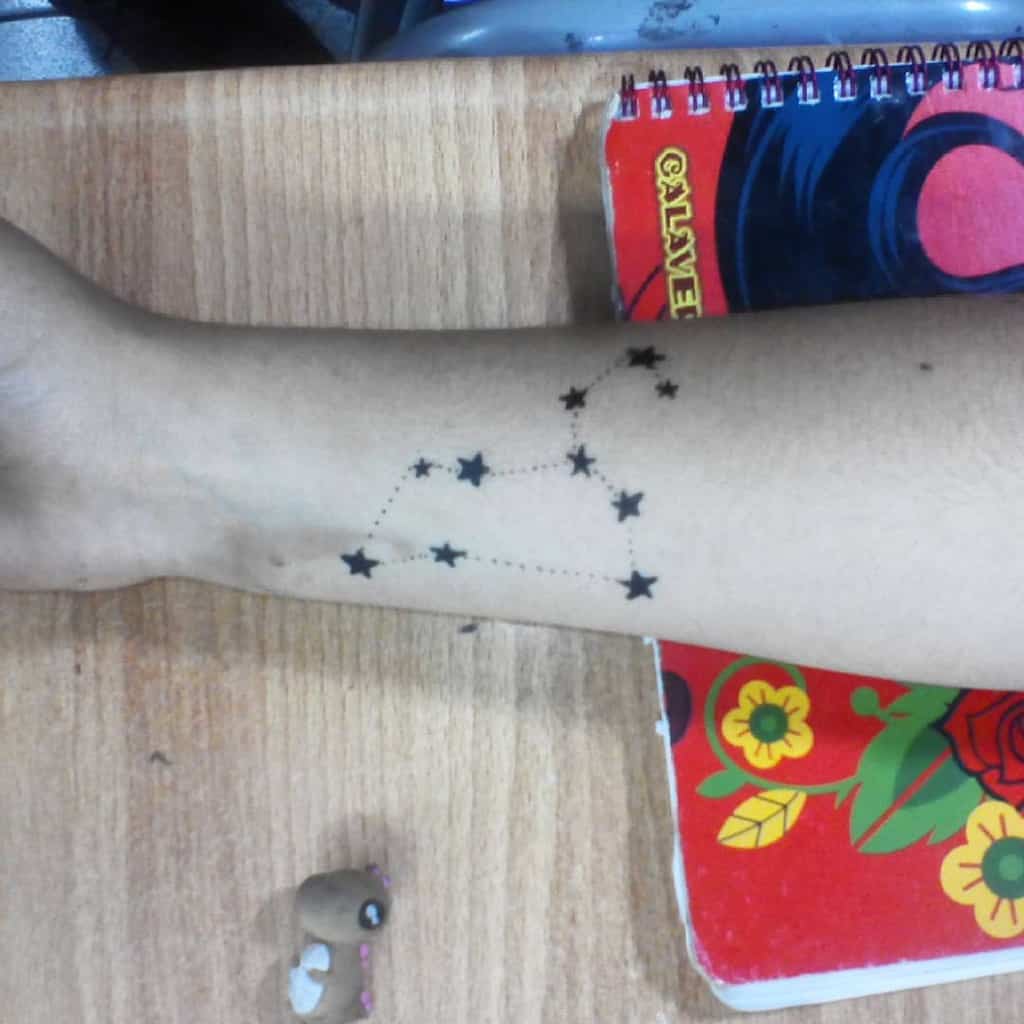 Black ink Leo constellation tattoo with solid stars and fine dot work, representing strength and celestial beauty.